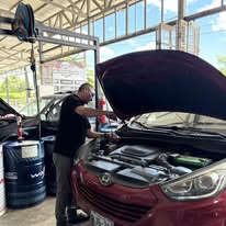 Mecánico realizando servicio de motor en vehículo Mazda
